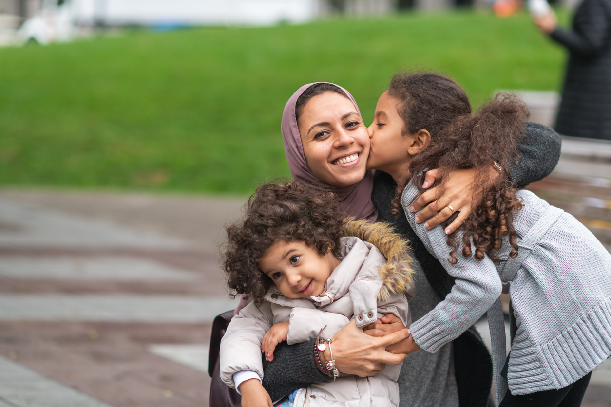 Middle Eastern Mother and Happy Children Hugging at the Park
