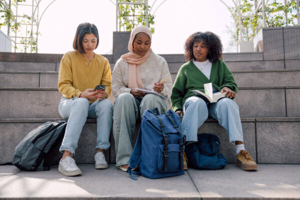 international college students reading in a park outdoors