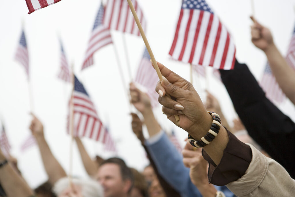 Crowd holding up small American flags.